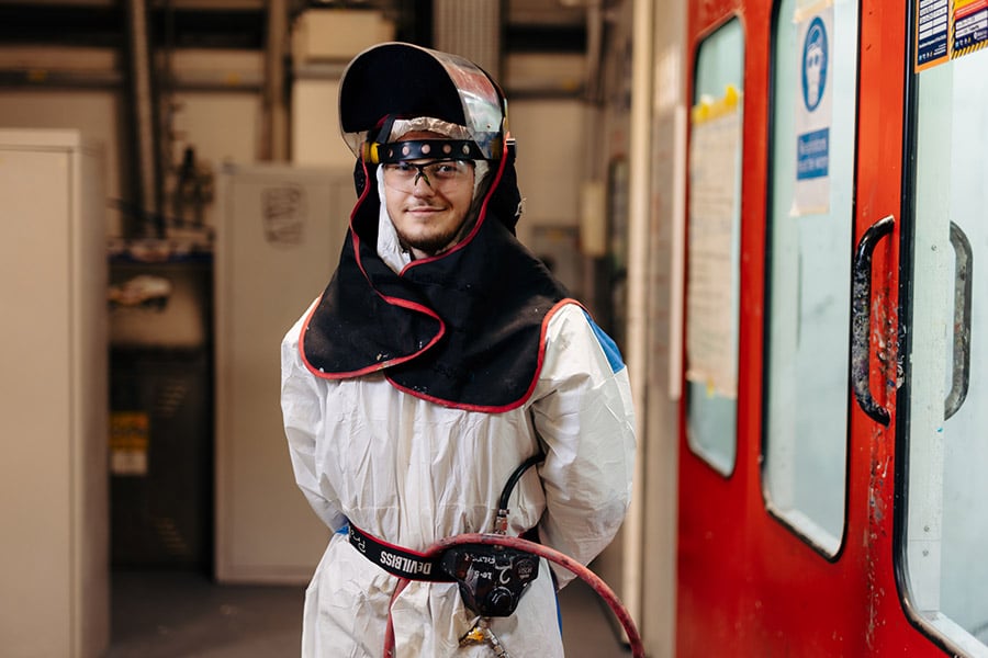 Hull College paint and body student dressed in PPE outside spray shop