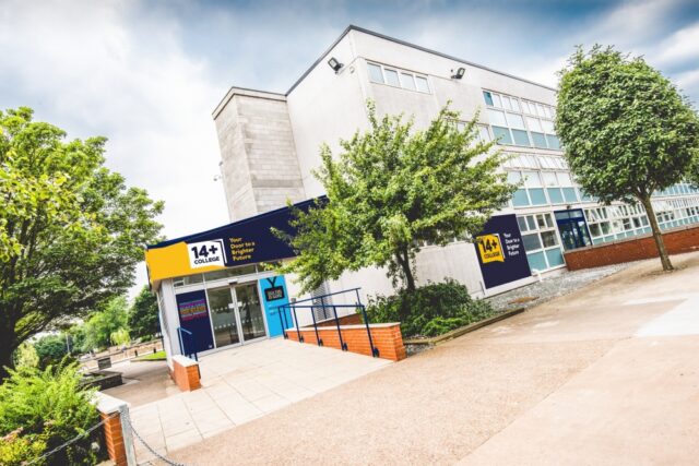 Modern college building with "14+ College" signage, surrounded by trees and a paved entrance. The scene conveys an inviting educational environment.
