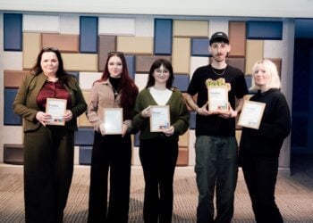 Five Hull College Art students stand in a row holding awards, smiling confidently. The background features a geometric pattern of muted colours. The mood is celebratory.