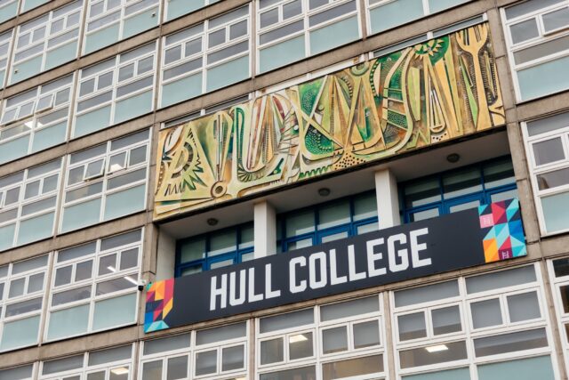 Exterior of a building showing a modern mural with abstract patterns above the entrance. A sign with "Hull College" stands out prominently.