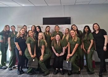 A group of women, mostly in green scrubs, pose for a cheerful photo at a charity event for Hull & East Yorkshire Breast Friends.