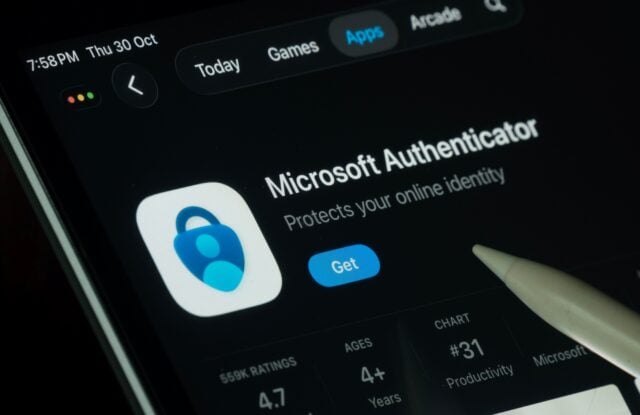 Close-up of a tablet showing the Microsoft Authenticator App Store page, with its blue lock icon, rating details, and a stylus pointing toward it.