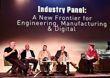 ive panelists sit onstage beneath the title “Industry Panel: A New Frontier for Engineering, Manufacturing & Digital,” in a formal, discussion-focused setting.
